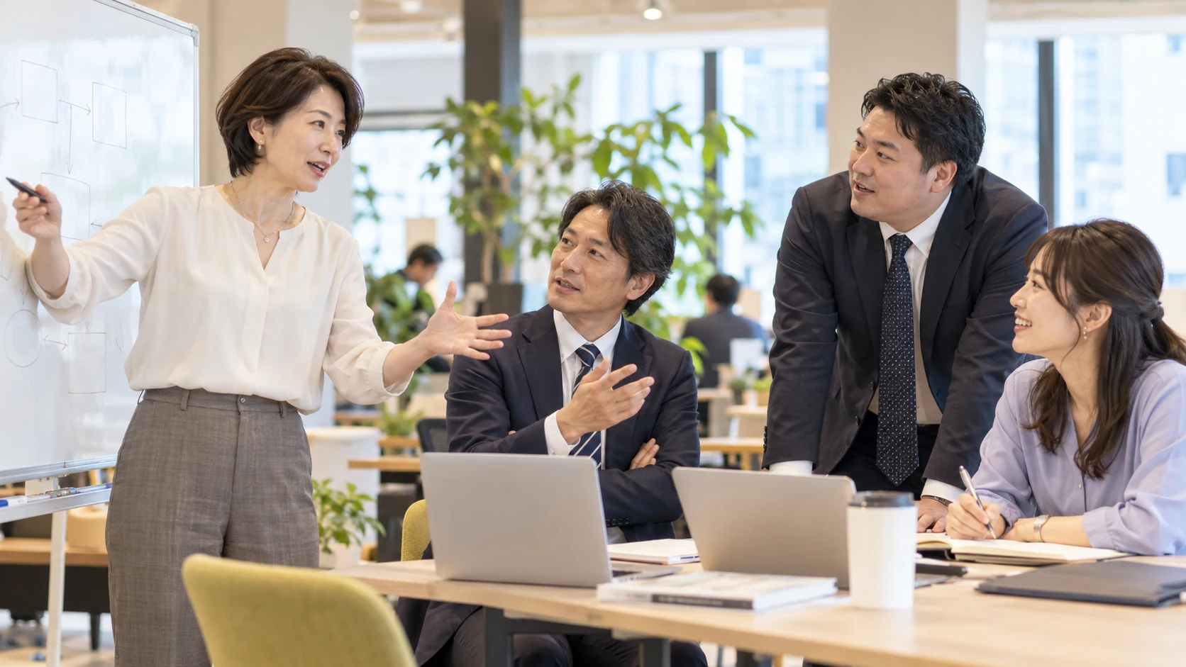 多様な経験を持つリーダーと技術者が、業務システムの新しい案を活発に話し合う情景