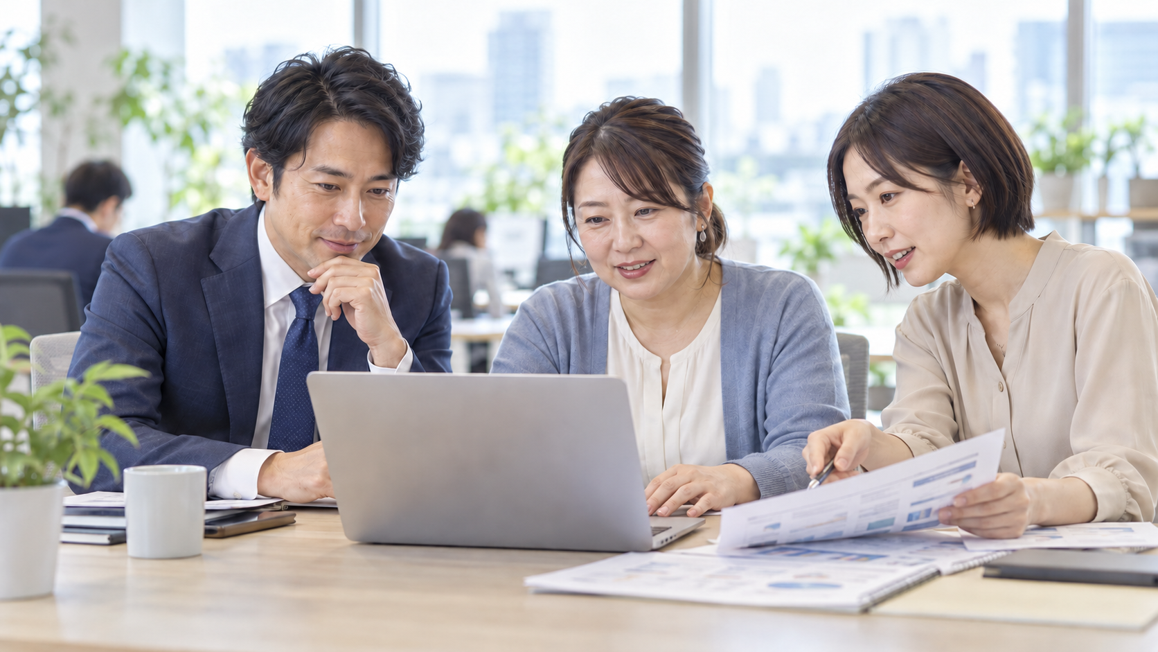 営業と営業事務がパソコンと資料を確認しながら商談を準備する情景