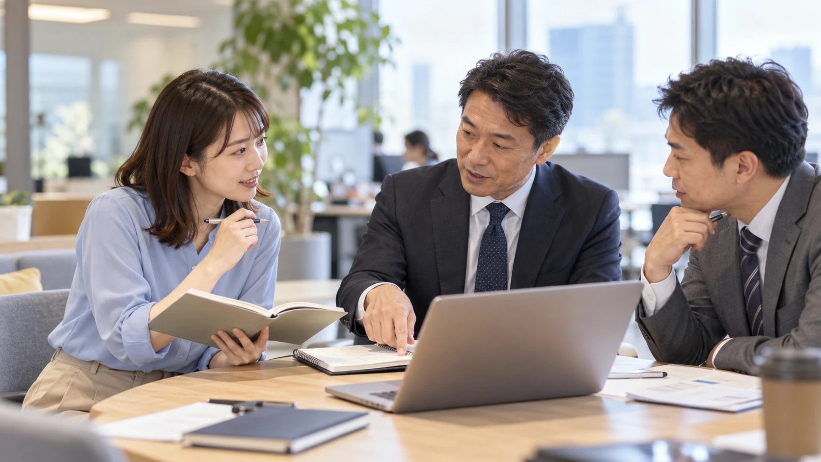 ノートを開き、先輩と商談を振り返る若手営業の情景